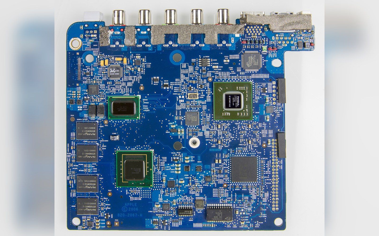 Blue circuit board with multiple chips, RCA connectors, and memory modules visible from above