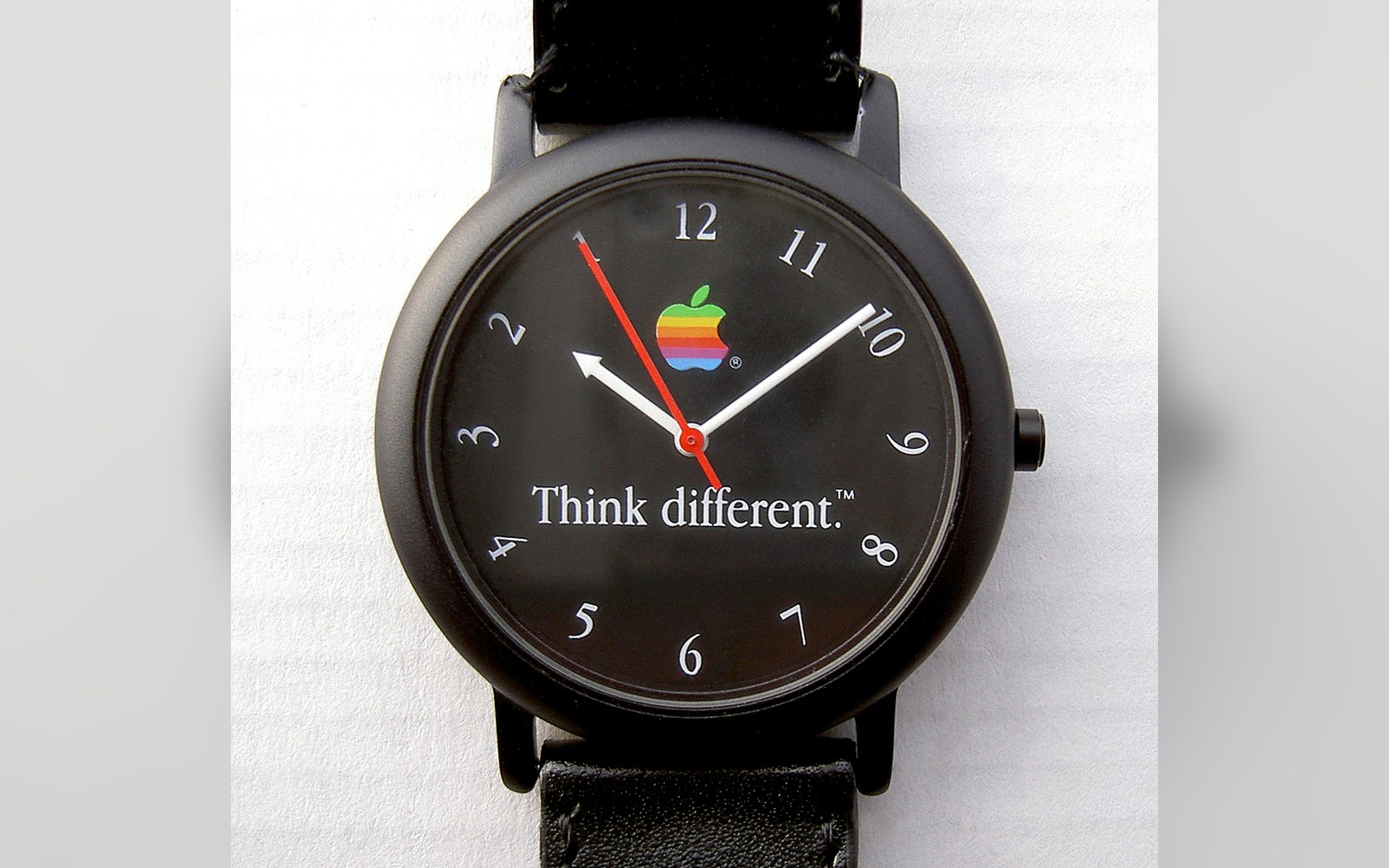 Black wristwatch with reversed numerals, rainbow Apple logo, and "Think different" text on the dial
